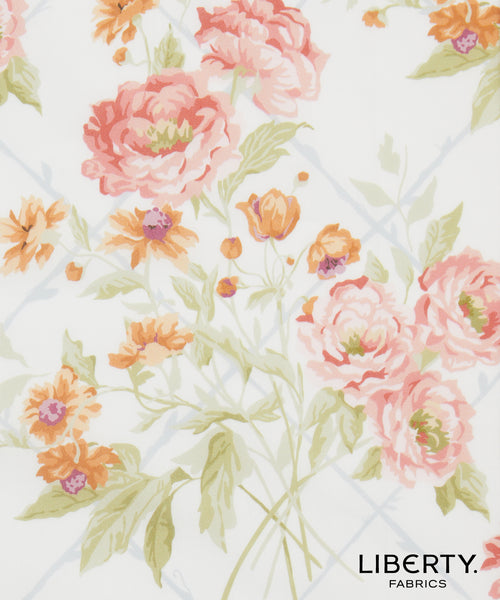 Liberty Fabrics floral pattern featuring large pink peonies, orange wildflowers, and green leaves on a white background with a faint blue grid.