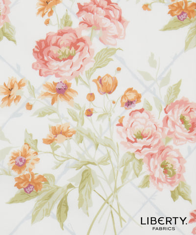 Liberty Fabrics floral pattern featuring large pink peonies, orange wildflowers, and green leaves on a white background with a faint blue grid.