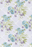 A close-up of a floral fabric pattern featuring light blue roses, purple blossoms, and green leaves over a white trellis design on a pale lavender background.