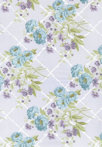 A close-up of a floral fabric pattern featuring light blue roses, purple blossoms, and green leaves over a white trellis design on a pale lavender background.