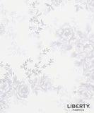 Liberty Fabrics floral pattern fabric swatch featuring light lavender and gray floral motifs on a warm off-white background, with the Liberty Fabrics logo in the bottom right corner.
