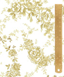 A close-up of a floral toile pattern in muted gold and beige on a white background, with a wooden ruler along the right side for scale.