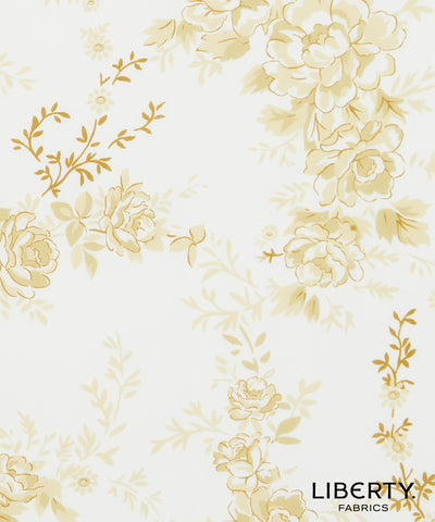 Liberty Fabrics floral patterned fabric featuring large cream and pale yellow flowers with gold outlines on a white background.