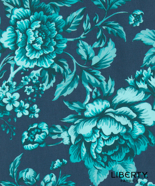 A close-up of a floral fabric pattern featuring large peony-like flowers and leaves in bright turquoise and light aqua on a dark navy blue background. The word 'LIBERTY' appears in the lower right corner, indicating the brand Liberty Fabrics.