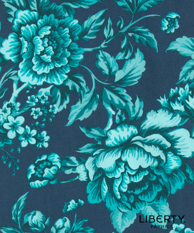 A close-up of a floral fabric pattern featuring large peony-like flowers and leaves in bright turquoise and light aqua on a dark navy blue background. The word 'LIBERTY' appears in the lower right corner, indicating the brand Liberty Fabrics.