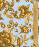 A close-up of a floral fabric pattern featuring large mustard yellow flowers and leaves on a light blue background, with a wooden ruler on the right side for scale.