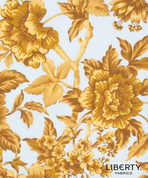 Liberty Fabrics floral pattern featuring large golden-yellow peony flowers and leaves on a light blue background, with the Liberty Fabrics logo in the bottom right corner.
