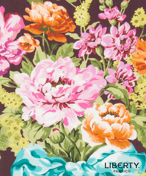 A close-up of Liberty Fabrics floral pattern featuring large pink and orange flowers with green leaves on a dark background, with the Liberty Fabrics logo in the bottom right corner.