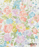 A close-up of a Liberty Fabrics floral pattern featuring watercolor-style flowers in pink, peach, purple, blue, yellow, and green on a white background, with the Liberty Fabrics logo in the bottom right corner.
