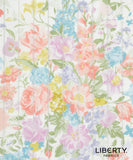 A close-up of a floral fabric print with pastel pink, blue, yellow, and lavender flowers on a white background, overlaid with vertical quilting stitches. The brand name 'LIBERTY.