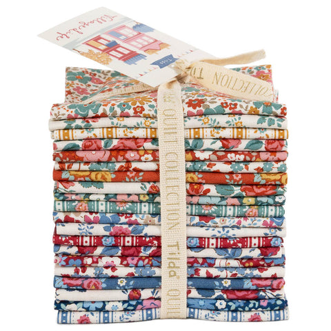 A stack of folded fabric pieces tied with a beige ribbon, featuring various floral and striped patterns in red, blue, green, orange, and yellow on white backgrounds. A paper tag is attached at the top.